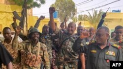 FILE - This picture released on the Sudanese army's Facebook page on May 30, 2023, shows army chief Abdel Fattah al-Burhan cheering with soldiers as he visits some of their positions in Khartoum. 