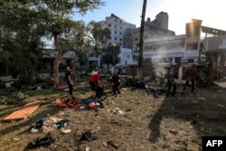 Sejumlah orang memeriksa puing-puing di luar Rumah Sakit Ahli Arab di Gaza usai ledakan hebat yang menewaskan ratusan orang pada malam sebelumnya, Rabu, 18 Oktober 2023.(Foto: Mahmud Hams/AFP)