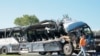 Seorang petugas membantu membereskan bus yang rusak akibat menabrak trailer di Highland. Illinois, pada 12 Juli 2023. (Foto: Christian Gooden/St. Louis Post-Dispatch via AP)