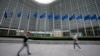 FILE - European Union flags wave in the wind as pedestrians walk by EU headquarters in Brussels, Sept. 20, 2023. 