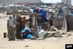 Palestinci demontiraju svoj šator dok se spremaju da pobegnu iz improvizovanog kampa za raseljene u Kan Junisu, u južnom Pojasu Gaze, nakon što su izraelski tenkovi zauzeli položaj na brdu iznad tog područja 18. avgusta 2024.