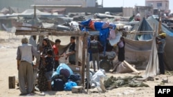 Palestinians dismantle their tent as they prepare to flee a makeshift camp for displaced people in Khan Younis in the southern Gaza Strip after Israeli tanks took position on a hill overlooking the area on Aug. 18, 2024.