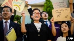 Climate activists cheer outside South Korea's Constitutional Court in Seoul on August 29, 2024, after the court ruled that much of the country's climate goals were unconstitutional.