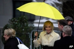 E. Jean Carroll, right, holds her umbrella as she arrives at federal court, in New York, Jan. 16, 2024.