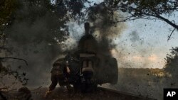 A Ukrainian policeman of special police unit fires a D-30 cannon towards Russian positions at the front line, near Kreminna, Luhansk region, Ukraine, July 7, 2023.