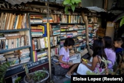 Children read books at Guanlao's home library in Makati, a metro area of Manila, Philippines, Feb. 7, 2024. (REUTERS/Eloisa Lopez)