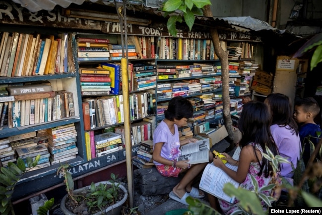 Children read books at Guanlao's home library in Makati, a metro area of Manila, Philippines, Feb. 7, 2024. (REUTERS/Eloisa Lopez)