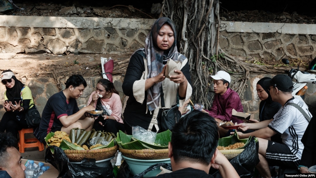 Seorang penjual makanan menyiapkan sarapan pada akhir pekan dalam acara car-free day di Jakarta, 4 Agustus 2024. (Foto: Yashuyoshi Chiba/AFP)