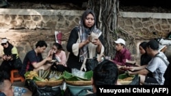 Seorang penjual makanan menyiapkan sarapan pada akhir pekan dalam acara car-free day di Jakarta, 4 Agustus 2024. (Foto: Yashuyoshi Chiba/AFP)