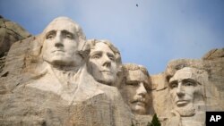 FILE - A massive sculpture carved into Mount Rushmore at the Mount Rushmore National Memorial, Sept. 21, 2023, in, Keystone, South Dakota. Fewer planes and helicopters will be flying tourists over Mount Rushmore and other national monuments and parks.