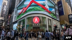 FILE - Pedestrians walk past a Hang Seng branch in Hong Kong, Oct. 28, 2022. Ratings agency Moody's downgraded the outlook on Hong Kong's credit rating to negative from stable, Dec. 6,2023, following a similar change for China the day before.