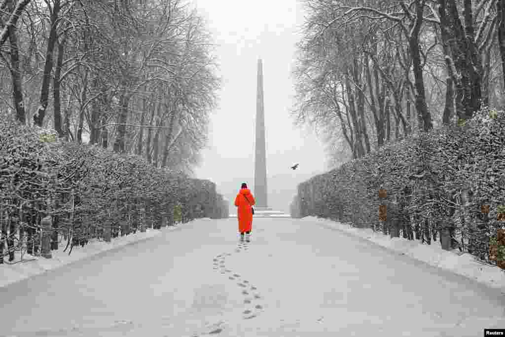 A woman walks in a snow-covered park during a first snowfall, amid Russia&#39;s attack in Ukraine, in Kyiv.