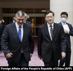 Russia's deputy foreign minister Andrey Rudenko (L) and China's Foreign Minister Qin Gang (R) walk together as they meet in Beijing, June 25, 2023.