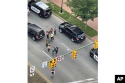 La gente se dispersa de la escena del tiroteo cuando llega la policía el martes 6 de junio de 2023 a Richmond, Virginia.