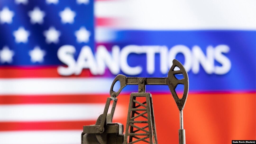 ILUSTRACIJA - Model pumpe za vađenje nafte ispred reči "Sankcije", američke i ruske zastave (Foto: Reuters/Dado Ruvić)