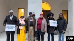 FILE - Plaintiffs Demba Dem, Fatou Camara, Madi Ceesay, Ramzia Diab, Binta Jamba and an unidentified accompanying person pose at the entrance of the Swiss Federal Criminal Court, on January 8, 2024.