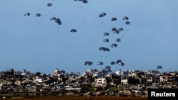 Pesawat militer menjatuhkan paket kemanusiaan, terlihat dari perbatasan Israel dengan Gaza di Israel selatan, 7 Maret 2024. (Foto: Reuters)