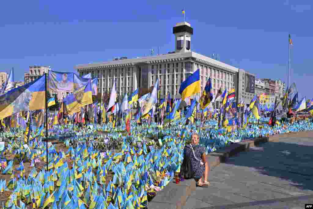 A woman visits a designated area for commemorating fallen Ukrainian soldiers at the Independence Square in Kyiv during the Remembrance Day of Defenders of Ukraine.