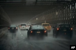 Los automóviles avanzan a lo largo del Puente de Brooklyn bajo una fuerte lluvia el viernes 29 de septiembre de 2023 en el distrito de Brooklyn de Nueva York. (Foto AP/Andrés Kudacki).