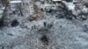 People stand next to a destroyed residential house and a crater at the site of a Russian missile strike in Dnipropetrovsk Region, Ukraine, Jan. 8, 2024. 