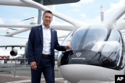 Volocopter CEO Dirk Hoke poses for a picture next to the Volocopter 2X, an electric vertical takeoff and landing multicopter, during the Paris Air Show in Le Bourget, north of Paris, France, Monday, June 19, 2023. (AP Photo/Lewis Joly)