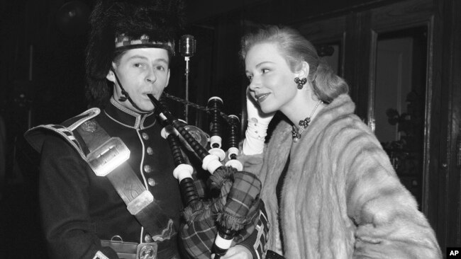 FILE - Actress Piper Laurie watches piper Thomas Gorrian of the Lovat Pipe Band before the premiere of a 3-D film, "King of the Khyber Rifles," in New York, Dec. 23, 1953.
