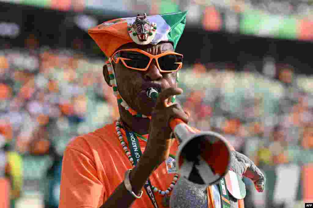 Un supporter ivoirien souffle dans une vuvuzela avant le match de football du groupe A de la Coupe d&#39;Afrique des Nations (CAN) 2024 entre la Guinée équatoriale et la Côte d&#39;Ivoire au stade olympique Alassane Ouattara à Ebimpe, Abidjan, le 22 janvier 2024.