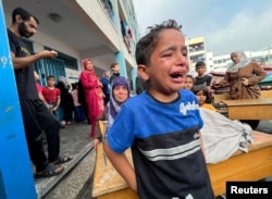 A Palestinian boy reacts at the damages at a U.N.-run school sheltering displaced people, following an Israeli strike, in Jabaliya in the northern Gaza Strip, Nov. 2, 2023.