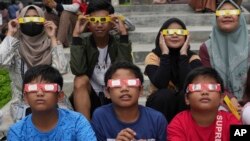 ARCHIVO: Un grupo de niños observa con gafas protectoras un eclipse parcial de sol en Yakarta, Indonesia, el 20 de abril de 2023.