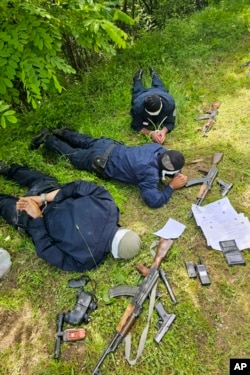 In this photo provided by the Serbian Ministry of Interior, a three Kosovo police officers captured by Serbian police officers lying face down on a field, June 14, 2023.