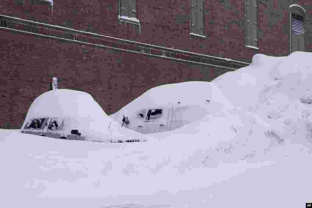 Carros y camionetas cubiertos de nieve durante la tormenta.