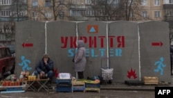 (FILE) People sell vegetables and other goods next to a bomb shelter at a market in Kramatorsk, Donetsk region, on January 19, 2024.