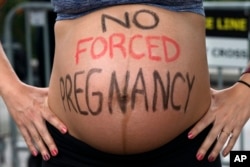 FILE - Krista Bywater shows her pregnant belly during a pro-abortion rally in front of the U.S. Supreme Court, May 14, 2022, in Washington.