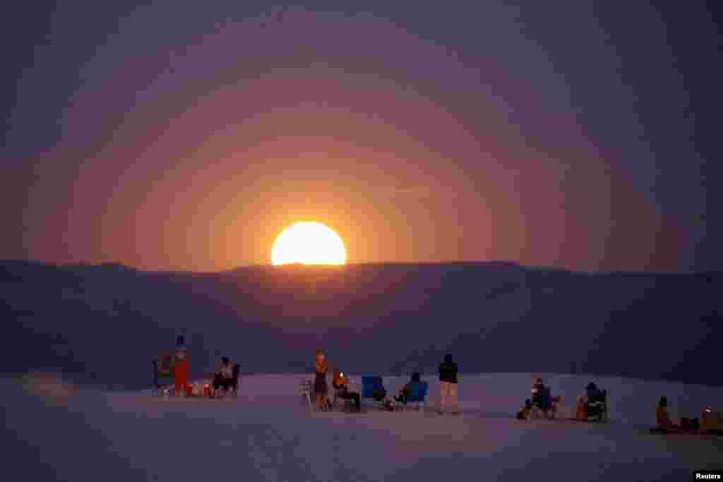 People gather to watch the supermoon, known as the blue moon, in White Sand National Park near Alamogordo, New Mexico, August 19, 2024.