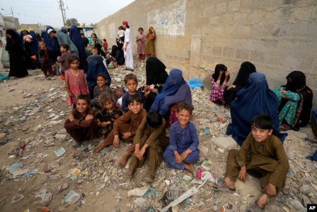 FILE - Afghan families wait to board a bus to depart for their homeland, in Karachi, Pakistan, Oct. 6, 2023. Pakistan's government announced a major crackdown on illegal migrants in the country. (AP Photo/Fareed Khan)