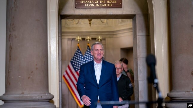Speaker of the House Kevin McCarthy, joined at right by his top negotiator on the debt limit, Rep. Patrick McHenry, smiles as he arrives to talk to reporters at the Capitol in Washington, May 28, 2023.