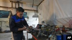 Khosro Dahaghin works in Roudehen, 30 miles (45 km) east of Tehran, Iran, June 7, 2023. His passion for restoring Cadillac Sevilles requires examining each component carefully.