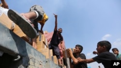 FILE - Palestinians take humanitarian aid from a truck near the Rafah border crossing in the Gaza Strip on Nov. 2, 2023. A different humanitarian convoy came under fire in Gaza City on Nov. 7 while on its way to deliver supplies to a hospital, the Red Cross said.