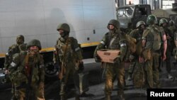 প্রাইভেট ভাড়াটে ওয়াগনার যোদ্ধারা রাশিয়ার রোস্তভ-অন-ডন শহরে ঘাঁটিতে ফিরে যাওয়ার জন্য দক্ষিণ সামরিক জেলার সদর দপ্তর থেকে বেরিয়ে এসেছে। ২৪ জুন, ২০২৩।