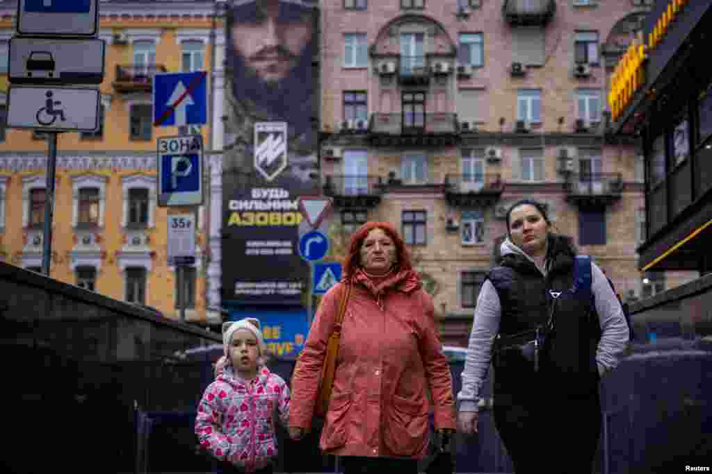 Una mujer y un niño caminan cerca de un cartel de reclutamiento para la Brigada de Asalto Azov de la Guardia Nacional de Ucrania, en Kiev, Ucrania, el 8 de noviembre de 2023.&nbsp; El informe del miércoles se refería a 35 niños de la ciudad ucraniana de Antratsyt, ocupada por Rusia, en el este de Ucrania. Según las autoridades bielorrusas, fueron enviados a la ciudad de Mogilev, en el este de Bielorrusia. &nbsp;