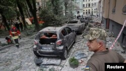 Rescue workers assess the damage left by a Russian missile that struck an apartment building in Lviv, Ukraine, July 6, 2023. At least four people were killed.