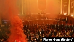 Um deputado do Partido Democrático, o maior partido da oposição da Albânia, acende uma bomba de fumo colorida em sinal de protesto durante uma sessão parlamentar em Tirana, Albânia, 20 de novembro de 2023. REUTERS