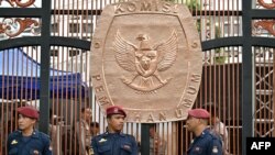 FILE - Aparat keamanan berdiri di depan logo Komisi Pemilihan Umum (KPU) Indonesia di Jakarta, 13 November 2023. (Adek BERRY/AFP). 