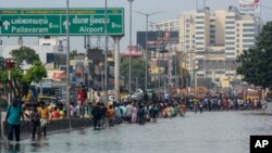 People wade through a flooded street following heavy rains along the Bay of Bengal coast in Chennai, India, Dec.5, 2023, as cyclone Michaung made landfall along the country's southeastern coastline.
