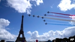 Patroli Udara Prancis terbang melewati Menara Eiffel dan melewati zona penggemar Olimpiade di Paris, Minggu, 8 Agustus 2021.(Foto: AP)