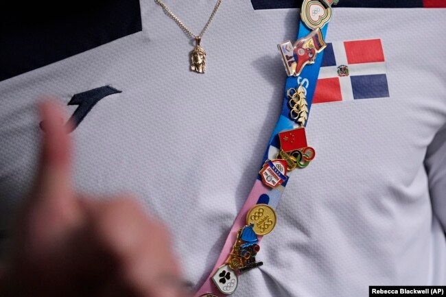 Atlet Republik Dominika Cristian Pinales memamerkan pin Olimpiade miliknya pada Olimpiade Musim Panas 2024, Selasa, 23 Juli 2024, di Paris, Prancis. (Foto: AP/Rebecca Blackwell)