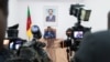 FILE - Cameroonian Prime Minister Joseph Dion Ngute speaks to journalists in Yaounde, Oct. 3, 2019. Ngute is sitting under a portrait of Cameroonian President Paul Biya who, now 91, may run for reelection next year.