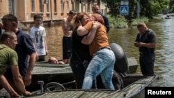 Local residents react after evacuation from a flooded area after the Kakhovka dam breached, in Kherson, Ukraine, June 9, 2023. 