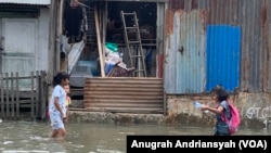 Anak-anak sedang bermain saat banjir rob melanda kawasan Kecamatan Medan Belawan, Kota Medan, Sumatra Utara, Jumat 19 Mei 2023