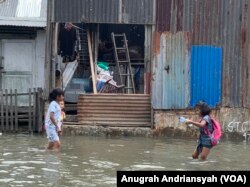 Anak-anak sedang bermain saat banjir rob melanda kawasan Kecamatan Medan Belawan, Kota Medan, Sumatra Utara. Jumat 19 Mei 2023